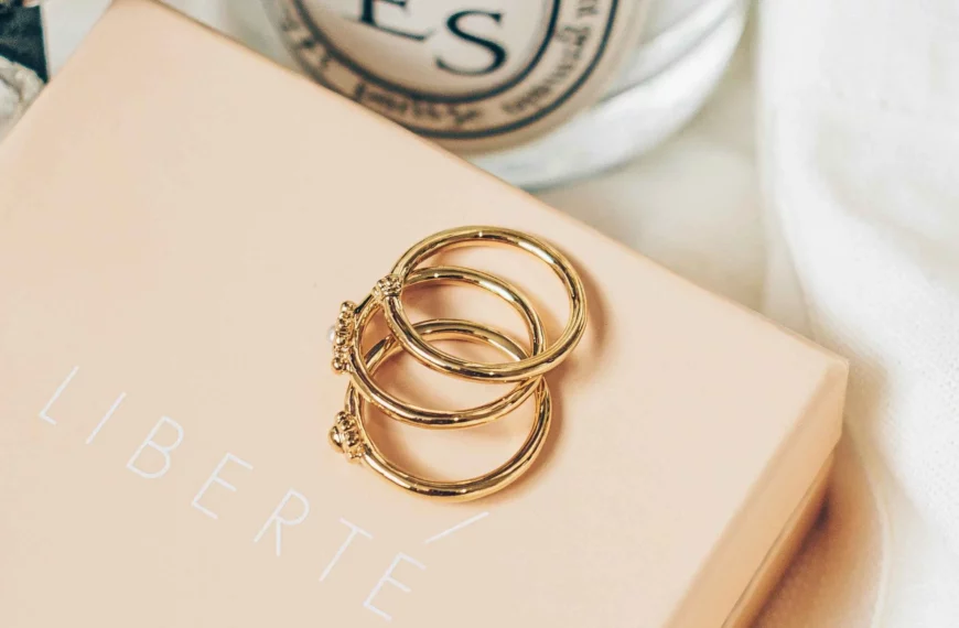 3 gold rings overlapping each other on a pink jewelry box that says Liberte