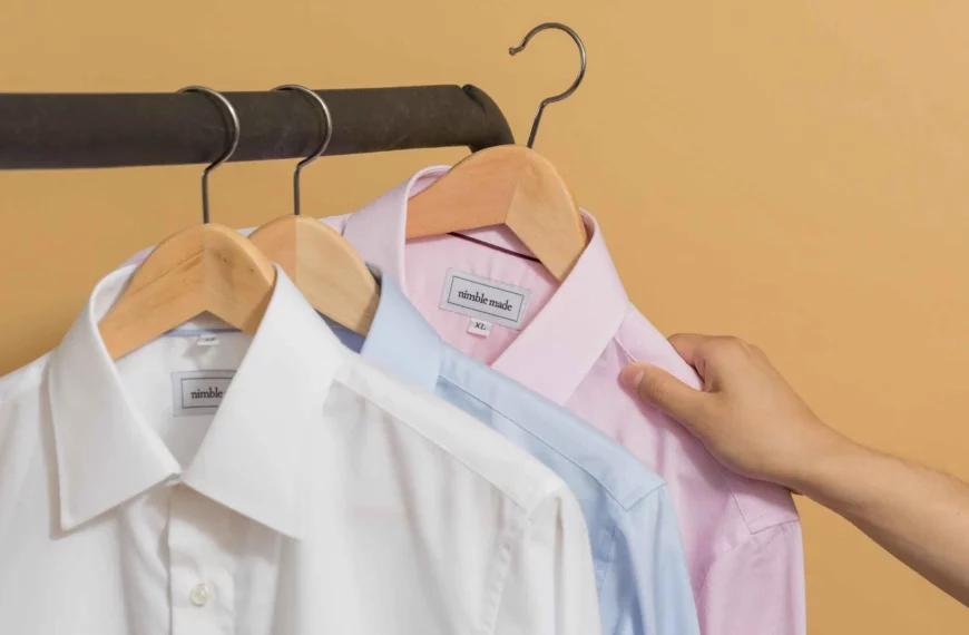 hand reaching for a button down shirt on a clothing rack