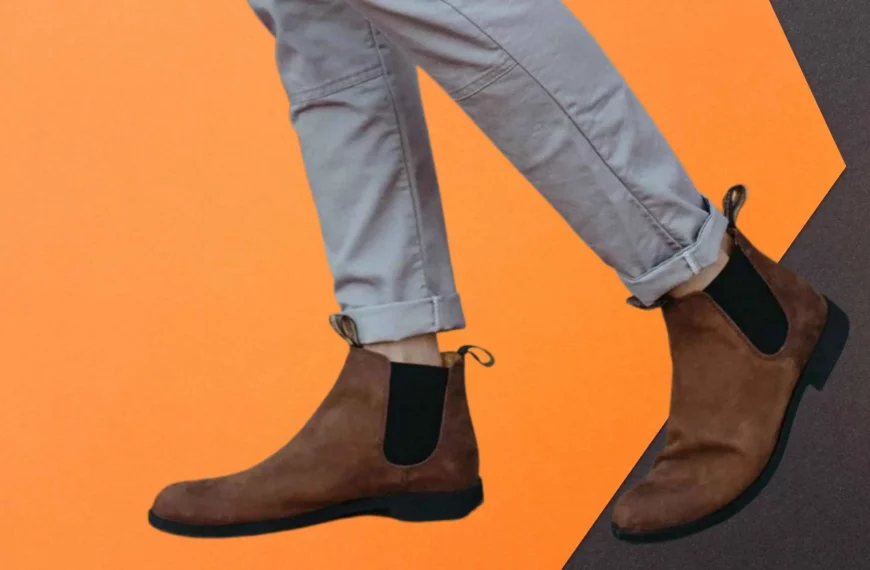 closeup of someone wearing brown Blundstone Chelsea boots and gray pants