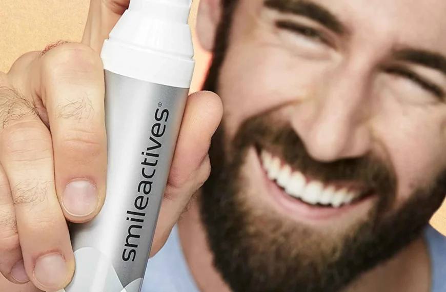 man smiling, face out of focus, holding up Smileactives whitening gel bottle