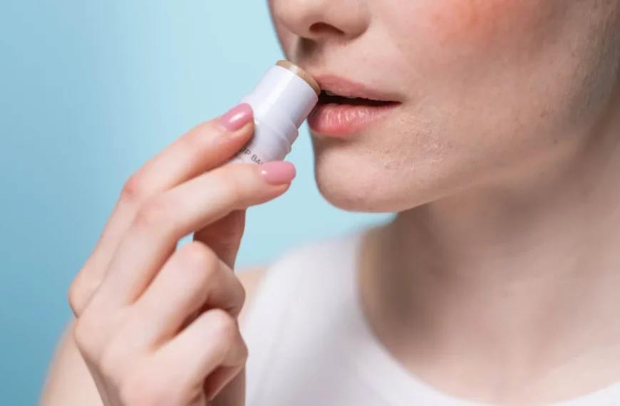 close up of woman applying lip balm to lips