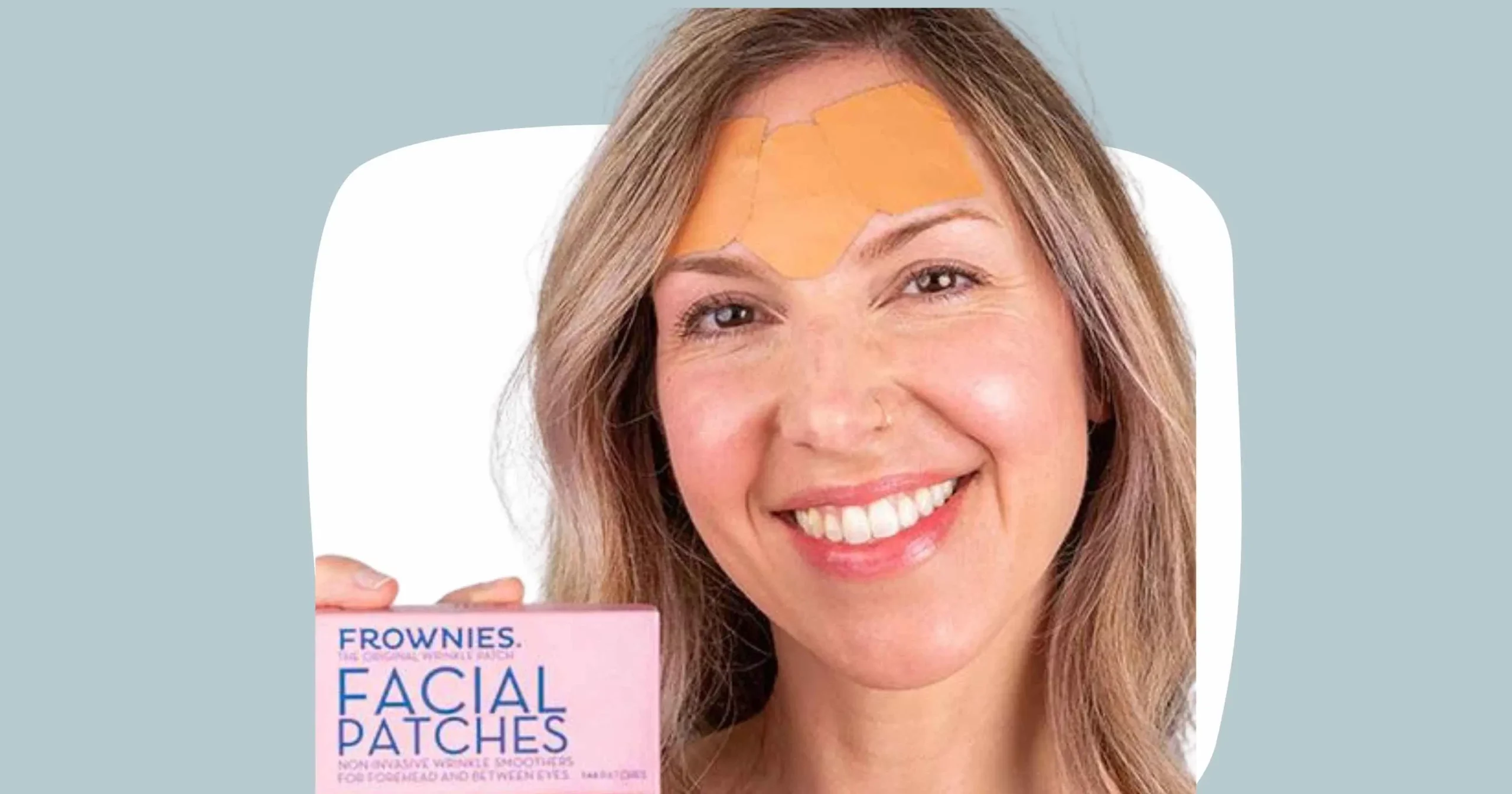 head shot of woman smiling, wearing Frownies facial patches on forehead, and holding a box of Frownies facial patches