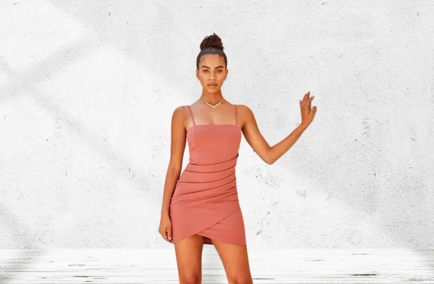 woman with hand against wall wearing short pink dress from Windsor