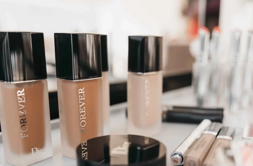 bb cream vs foundation: row of liquid foundation bottles and other makeup products on table