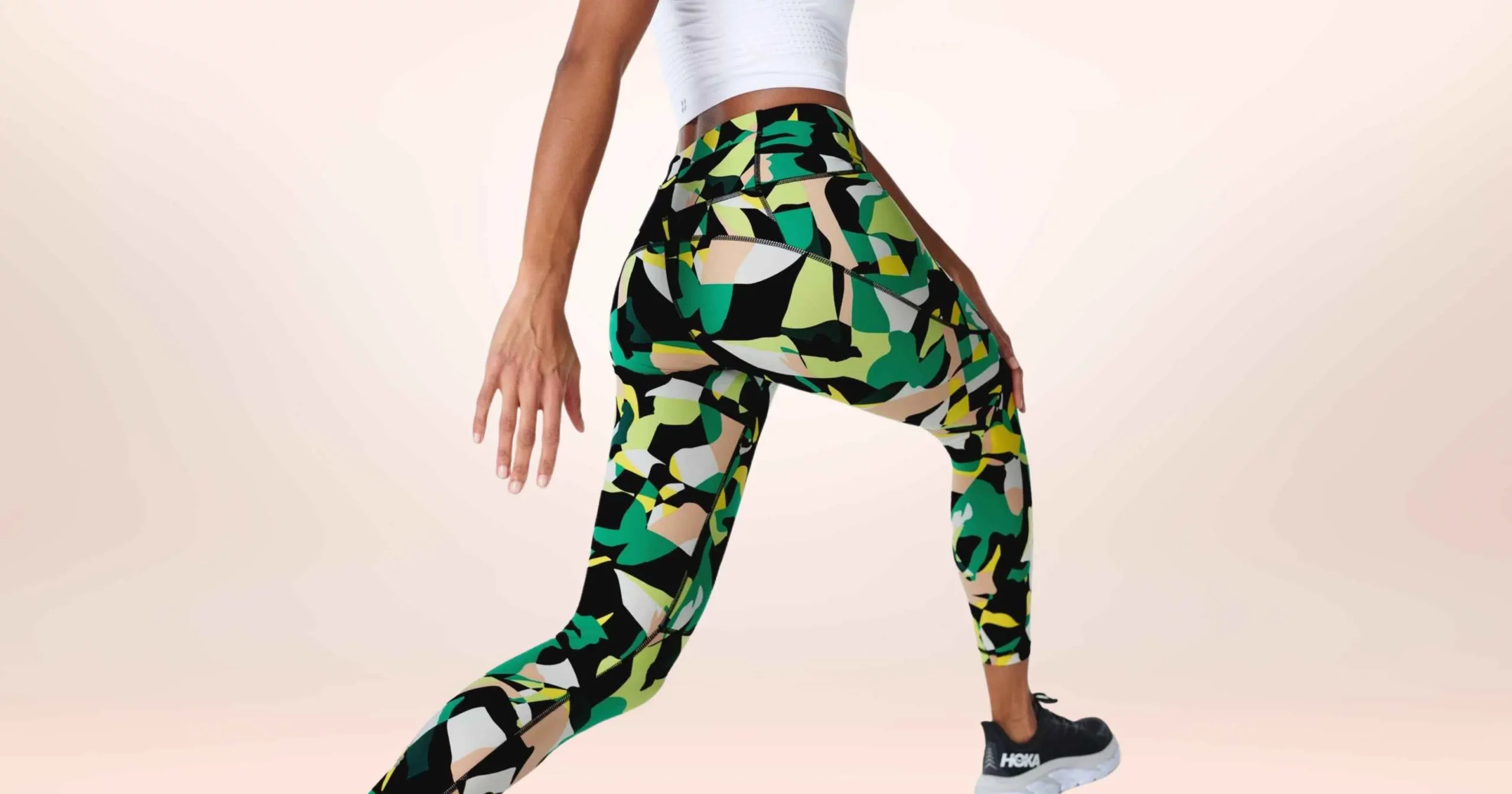 lower half of woman wearing white shirt and green, pink, and yellow print leggings from Sweaty Betty