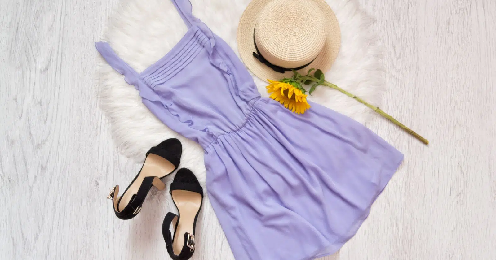 lavendar colored dress lying on floor next to black heels and tan hat