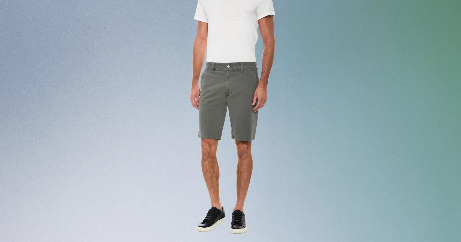 close up of man wearing white top, gray shorts, and black shoes