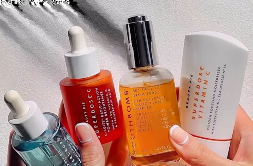 close up of person's hands holding different colored bottles of Beauty Pie products