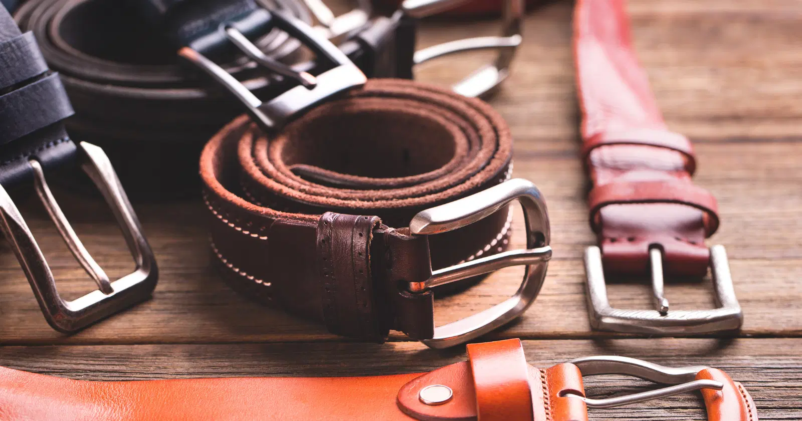 brown and black belts on wooden table