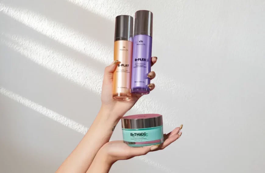 two hands holding up Maelys Cosmetics products in orange, purple, and green containers