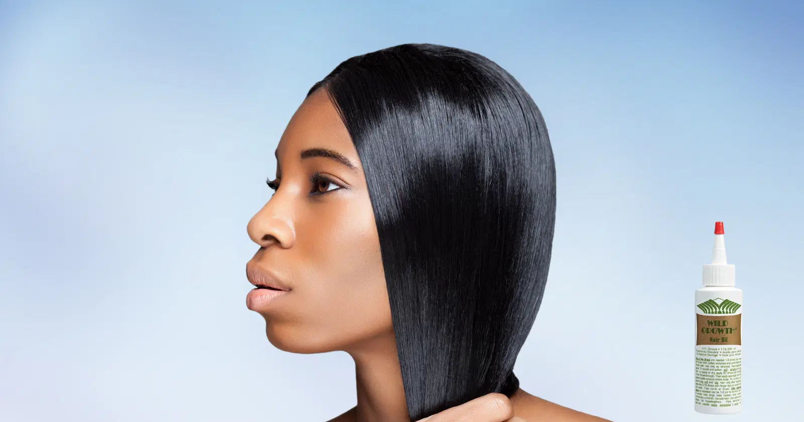 woman with shiny black hair looking off camera, a bottle of Wild Growth hair oil is in the corner of frame