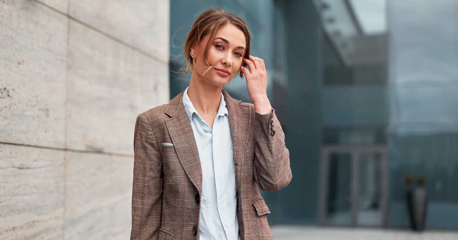 business casual woman in tweed jacket and light blue button down shirt