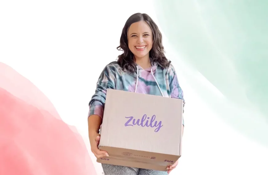 woman looking at camera, smiling, holding a box that says Zulily