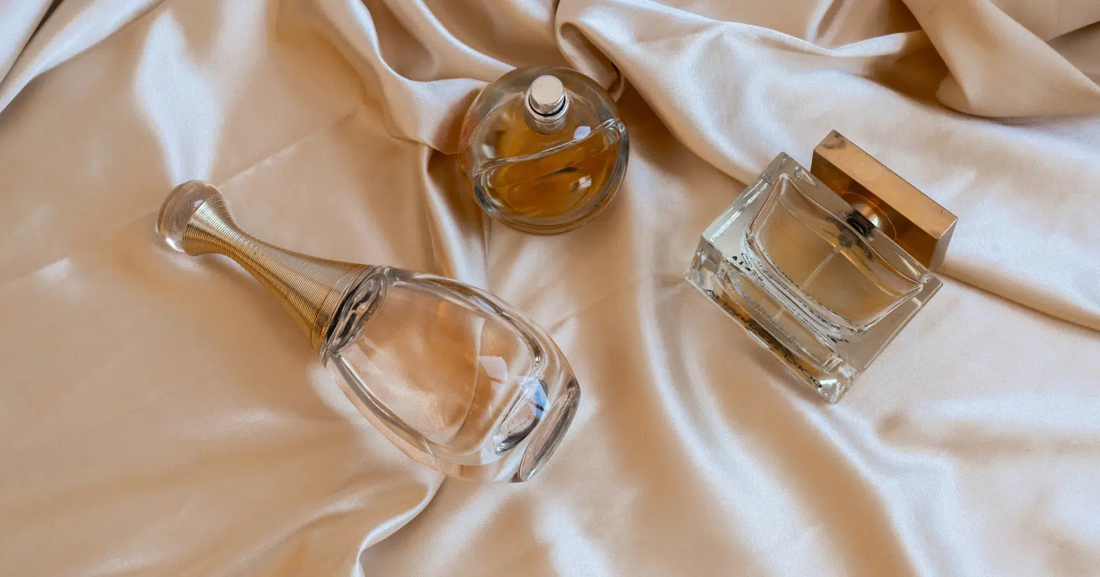 Light colored bottle of perfume and cologne on biege sheet