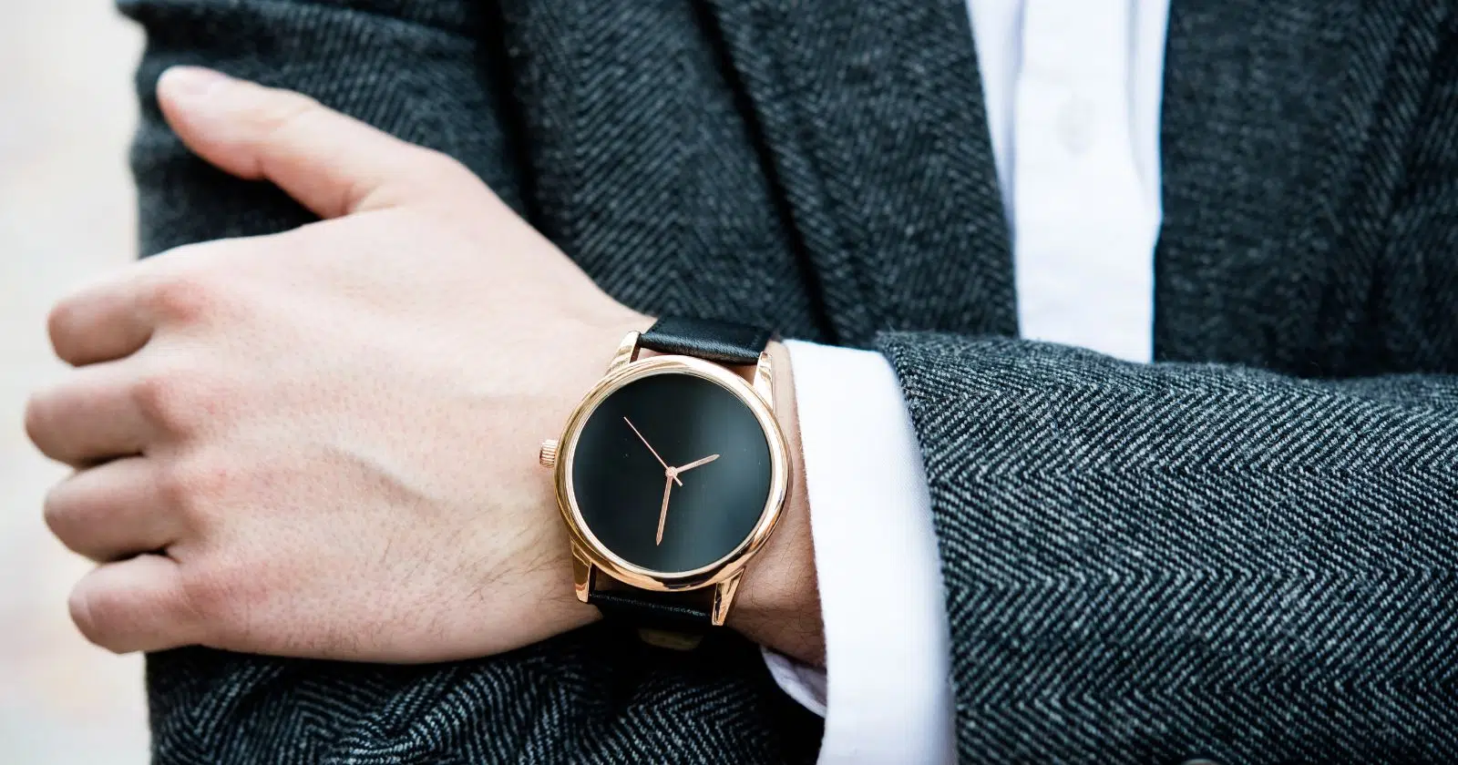 closeup of person's arm and hand wearing a black watch on wrist