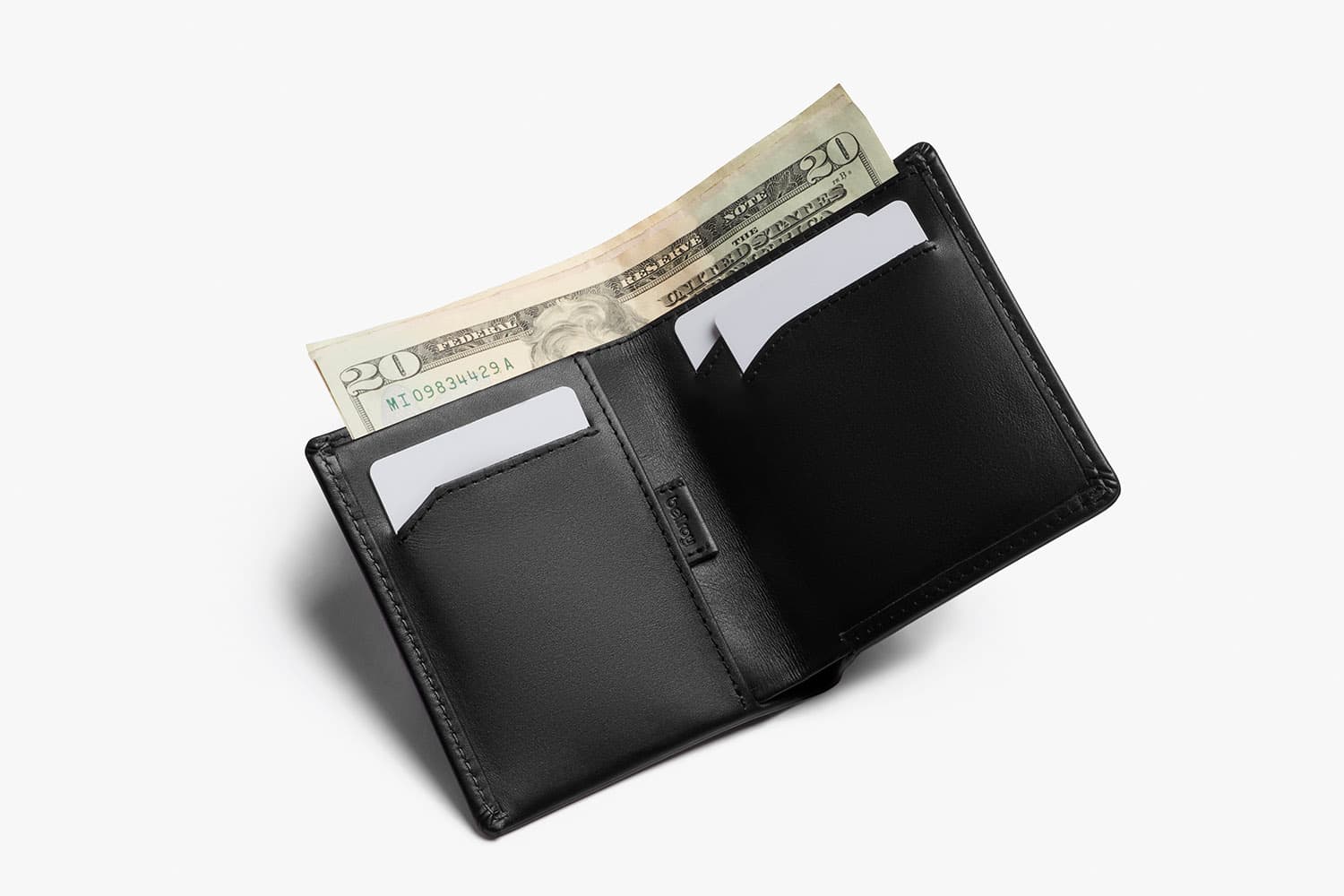 slim bellroy wallet in black open and filled with cards and money sticking out the top